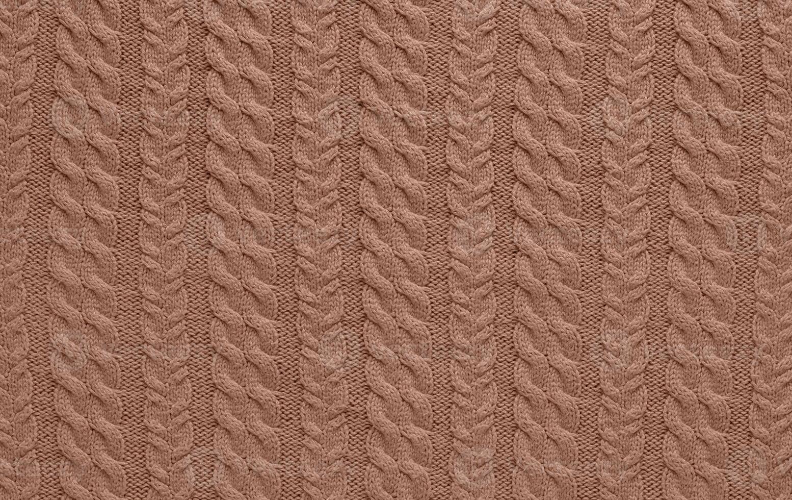 Texture of smooth knitted sweater with pattern. Handmade knitting wool or cotton fabric texture. Background of Large knit pattern with knitting needles or crochet. Mocha Mousse colour of 2025 year photo