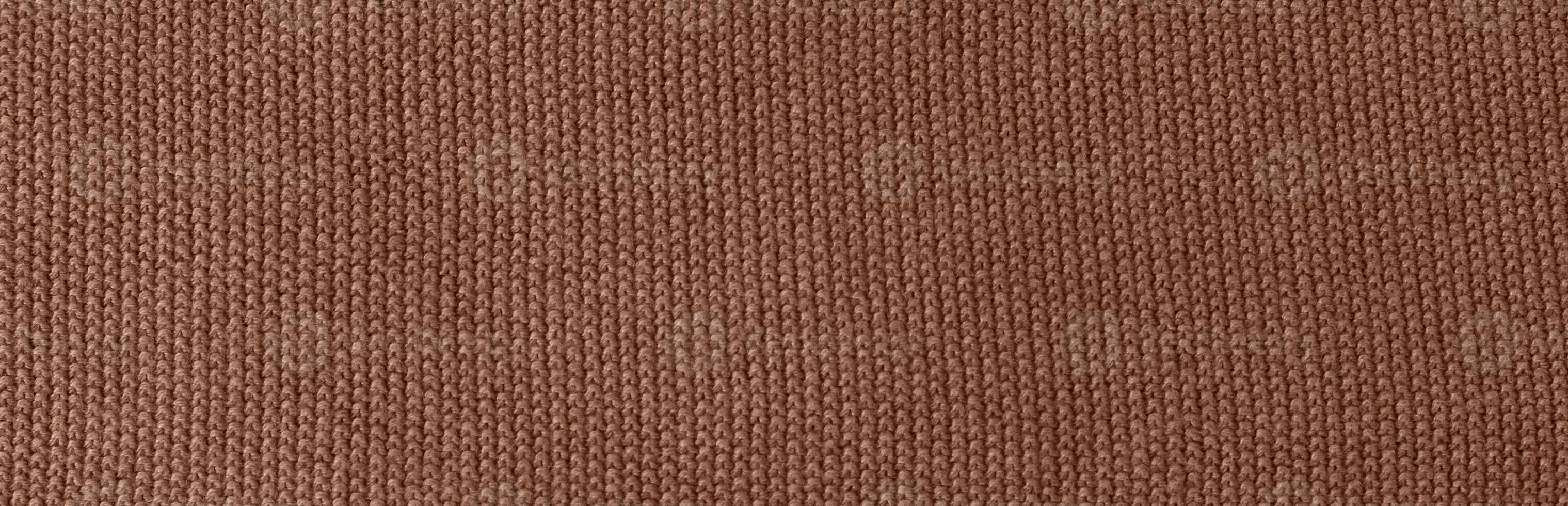 Texture of smooth knitted sweater with pattern. Handmade knitting wool or cotton fabric texture. Background of Large knit pattern with knitting needles or crochet. Mocha Mousse colour of 2025 year photo