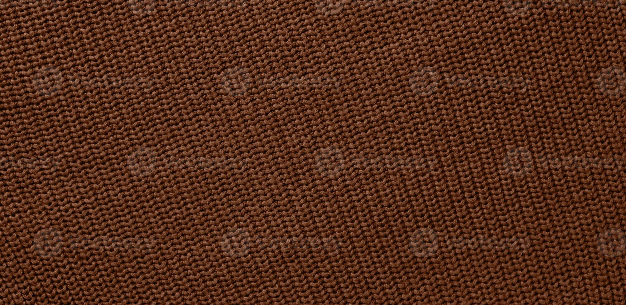 Texture of smooth knitted sweater with pattern. Handmade knitting wool or cotton fabric texture. Background of Large knit pattern with knitting needles or crochet. Mocha Mousse colour of 2025 year photo