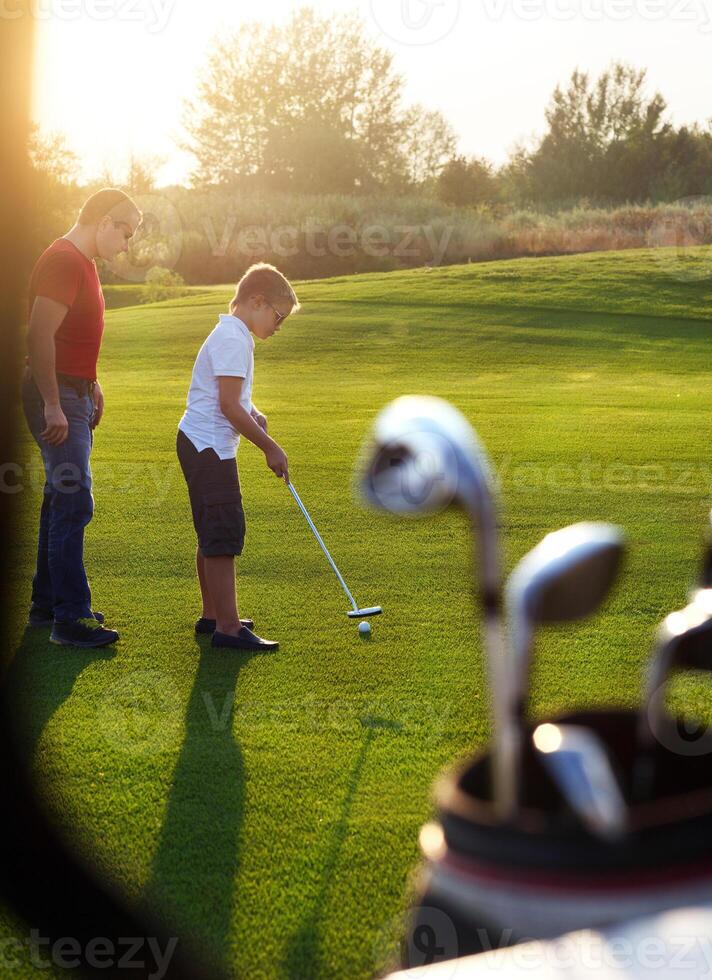 Father and his son playing golf together photo