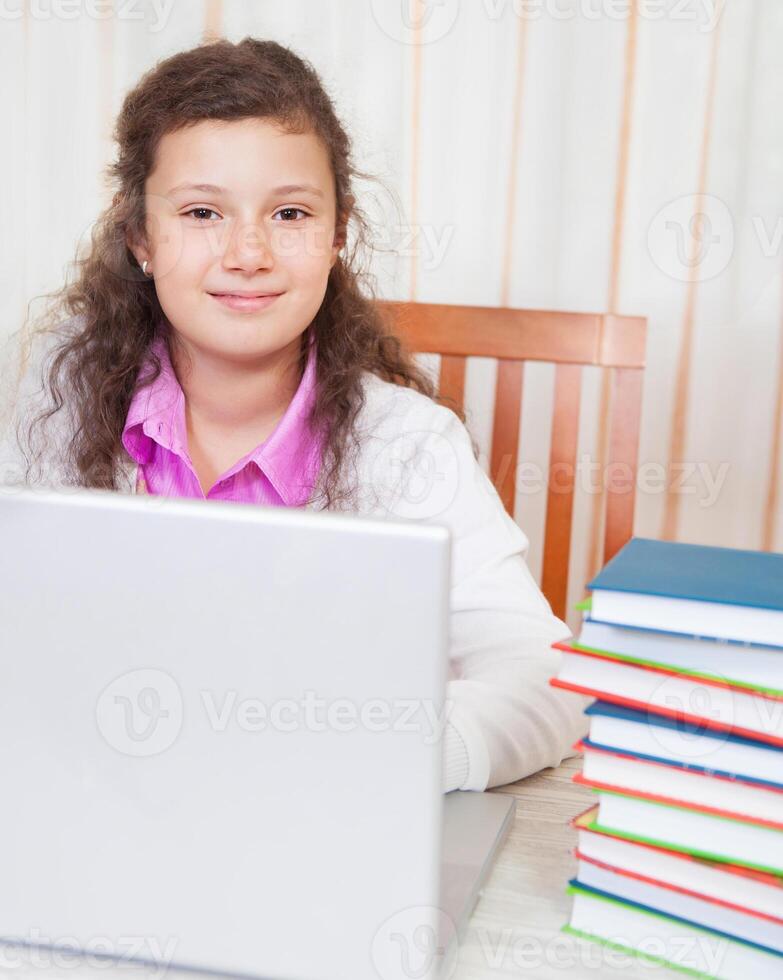 Little brunette smiling girl with laptop photo