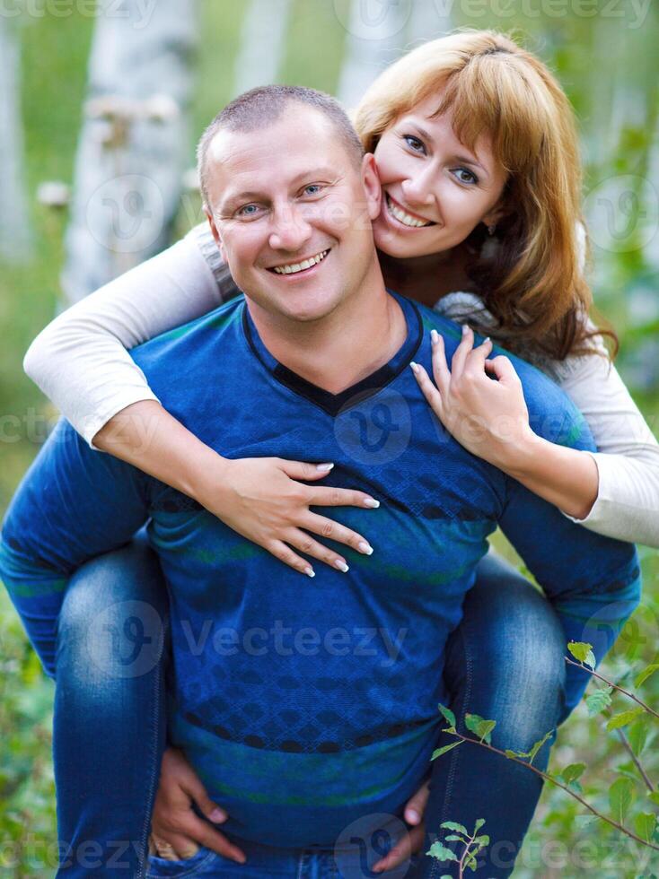 Happy smiling couple in the autumn forest photo