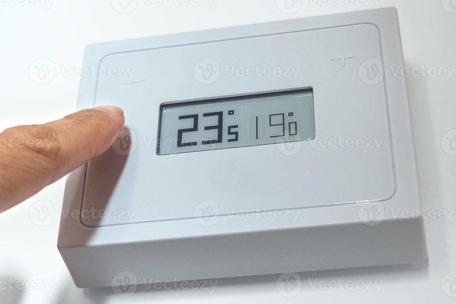 Lowering the temperature of a home thermostat due to energy crisis. photo