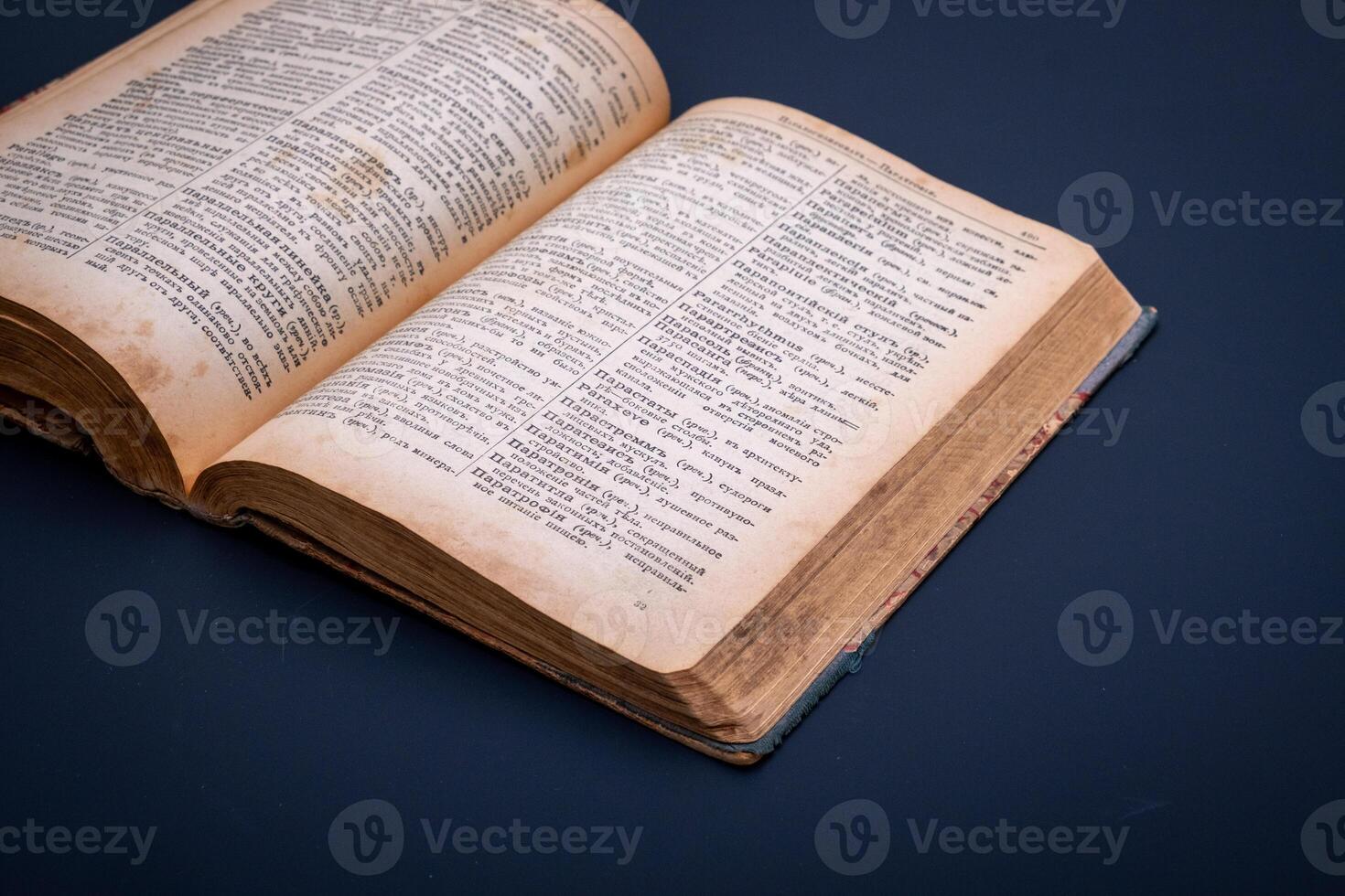 Close-up of an open antique dictionary against dark background. Selective focus photo