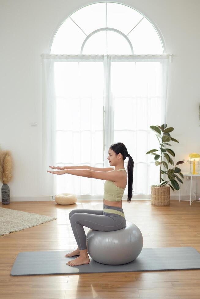 Young asian woman exercising with fitness ball photo