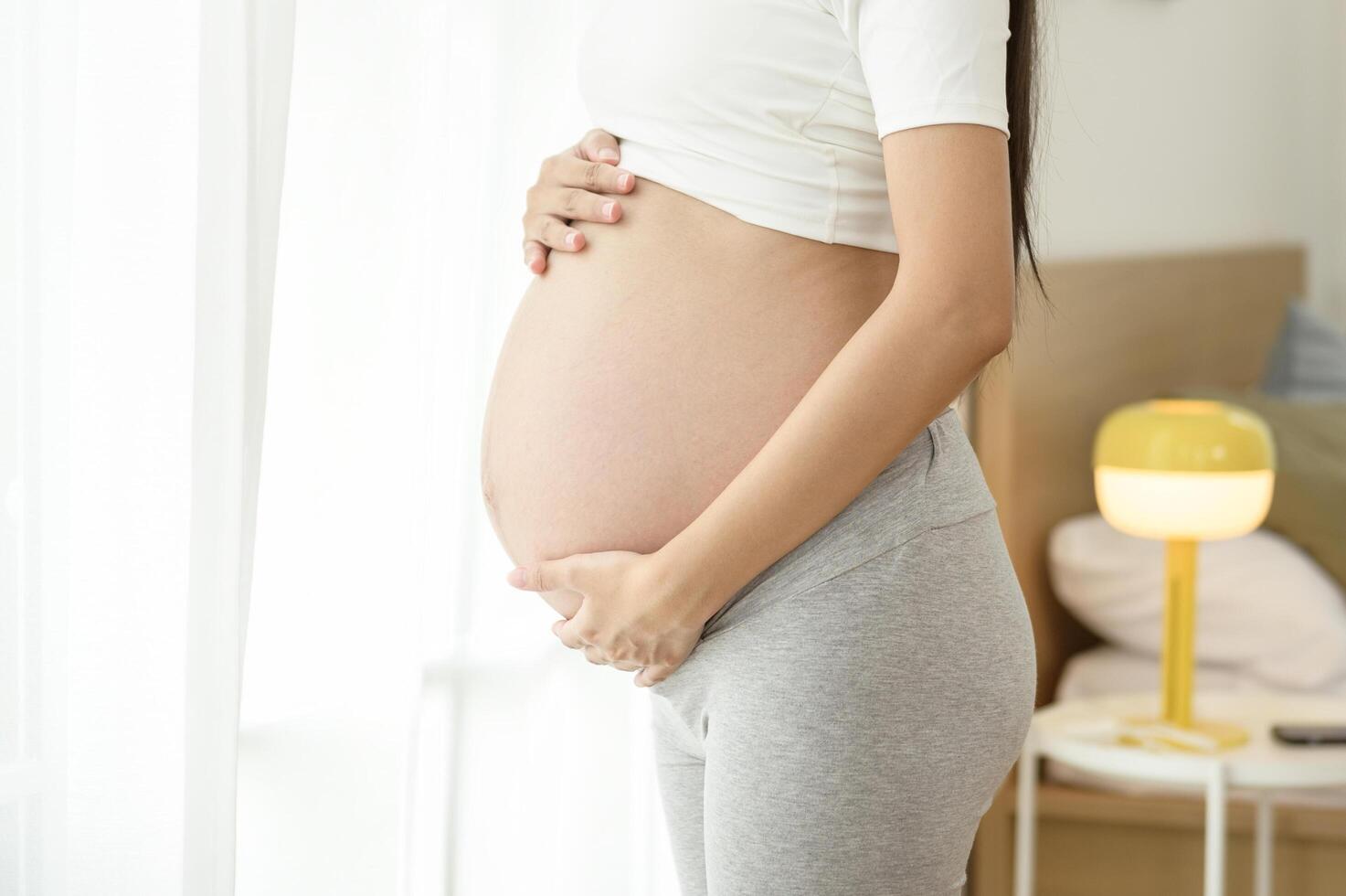 Beautiful asian pregnant woman expecting baby and touching her belly photo