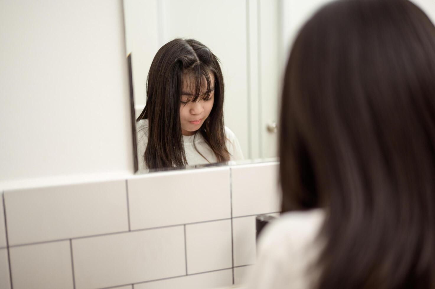 A young woman brushing her teeth in restroom photo