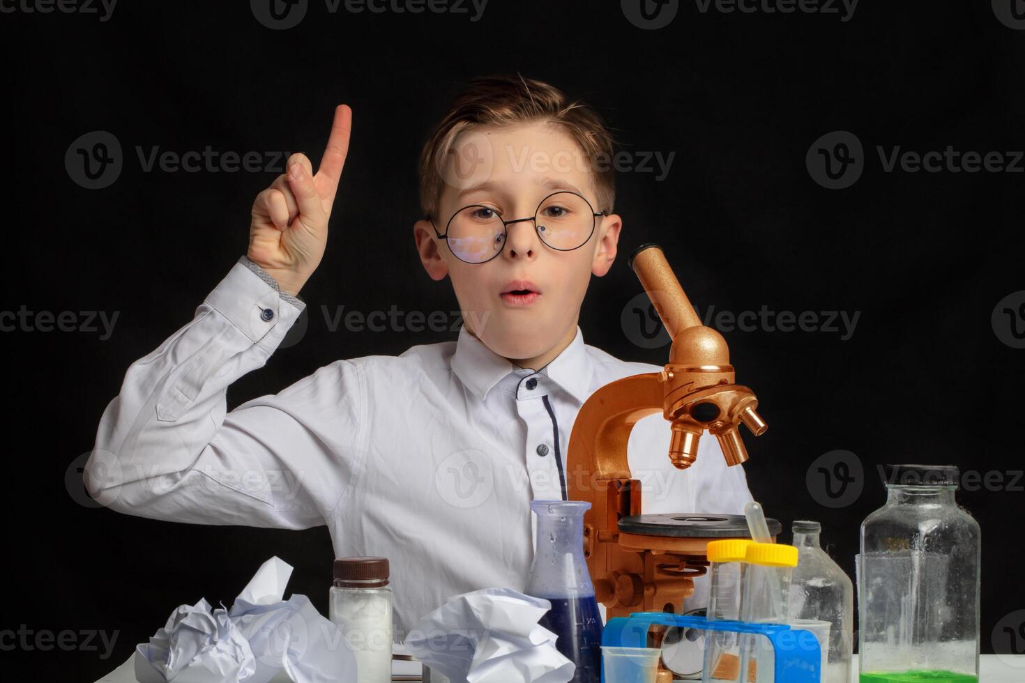 An interesting discovery was made by a little scientist wearing glasses who was studying through a microscope. photo