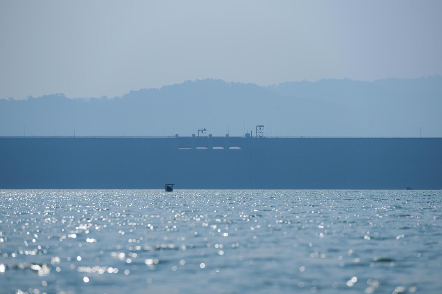 Tourist boats moored in the middle of the river at a massive water retention dam. photo