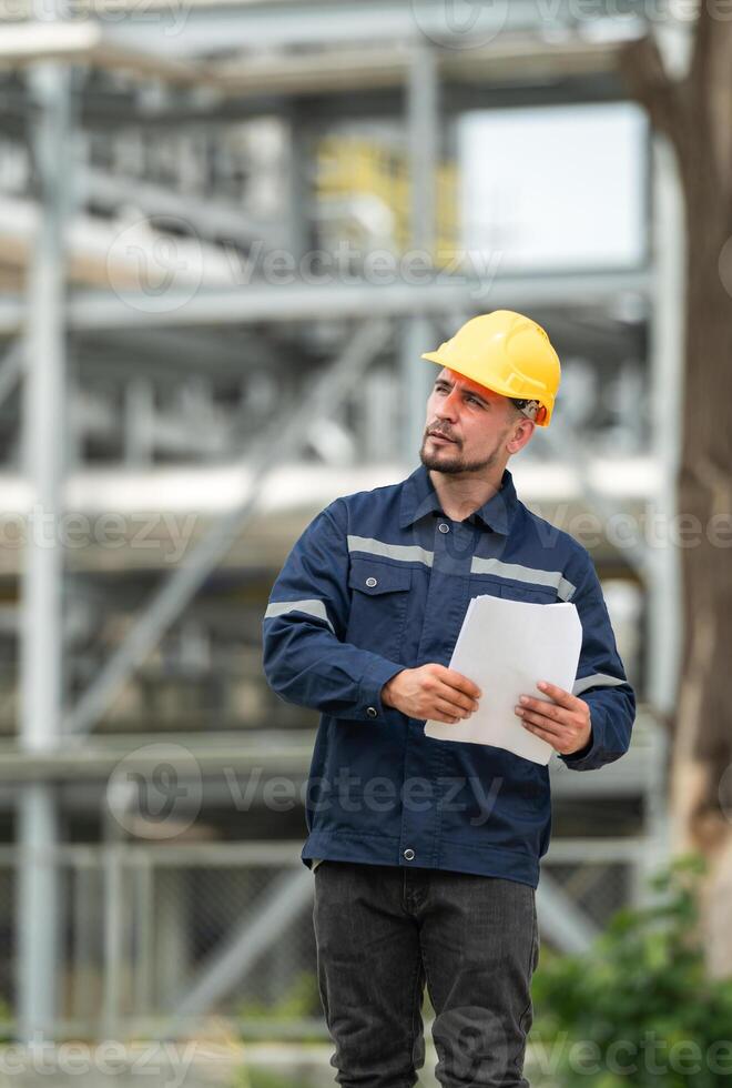 Petroleum engineer is on a mission to inspect oil distillation at a huge oil refinery photo