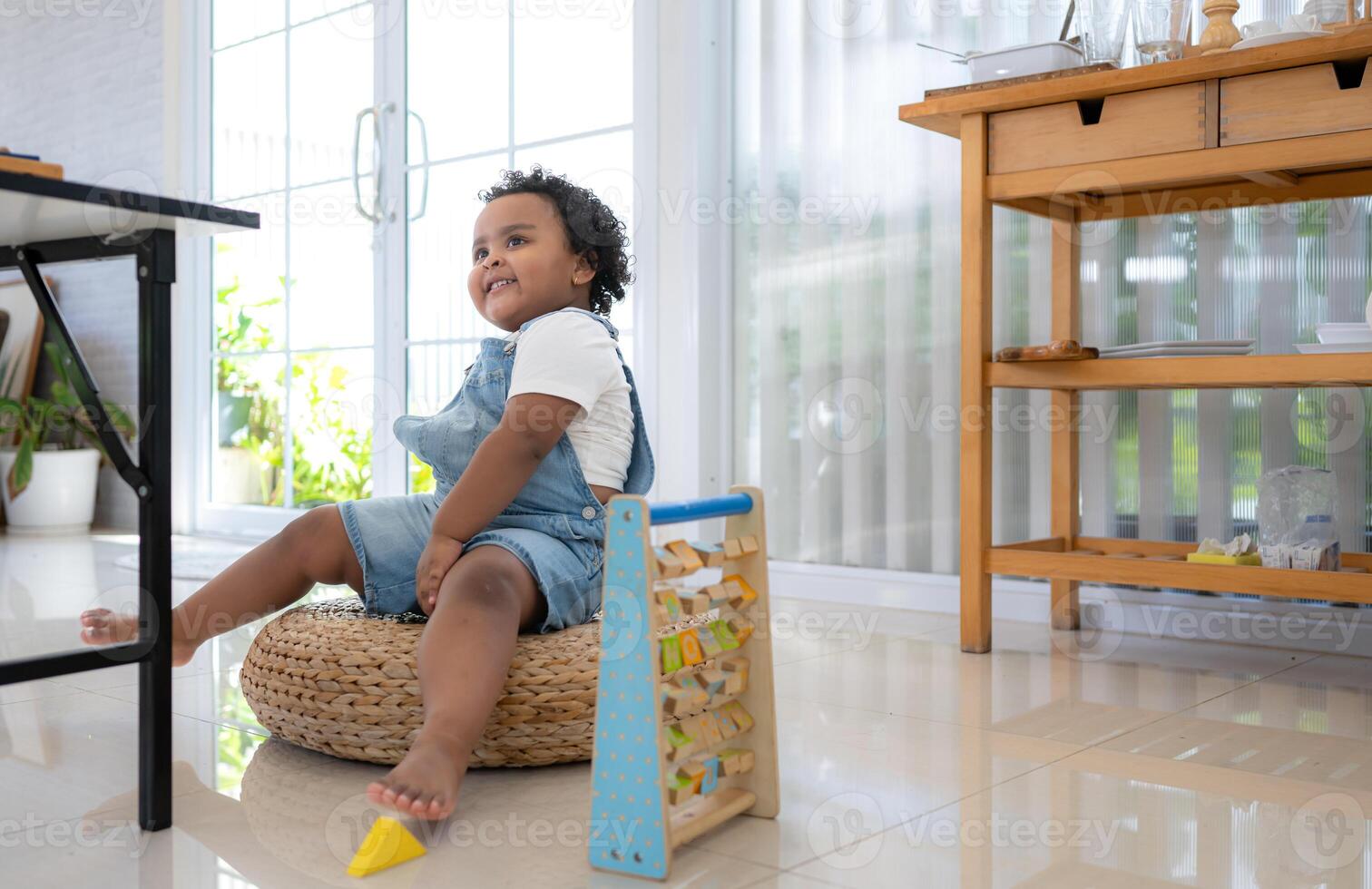 A little girl sit on the floor sit on the floor and play the toy photo