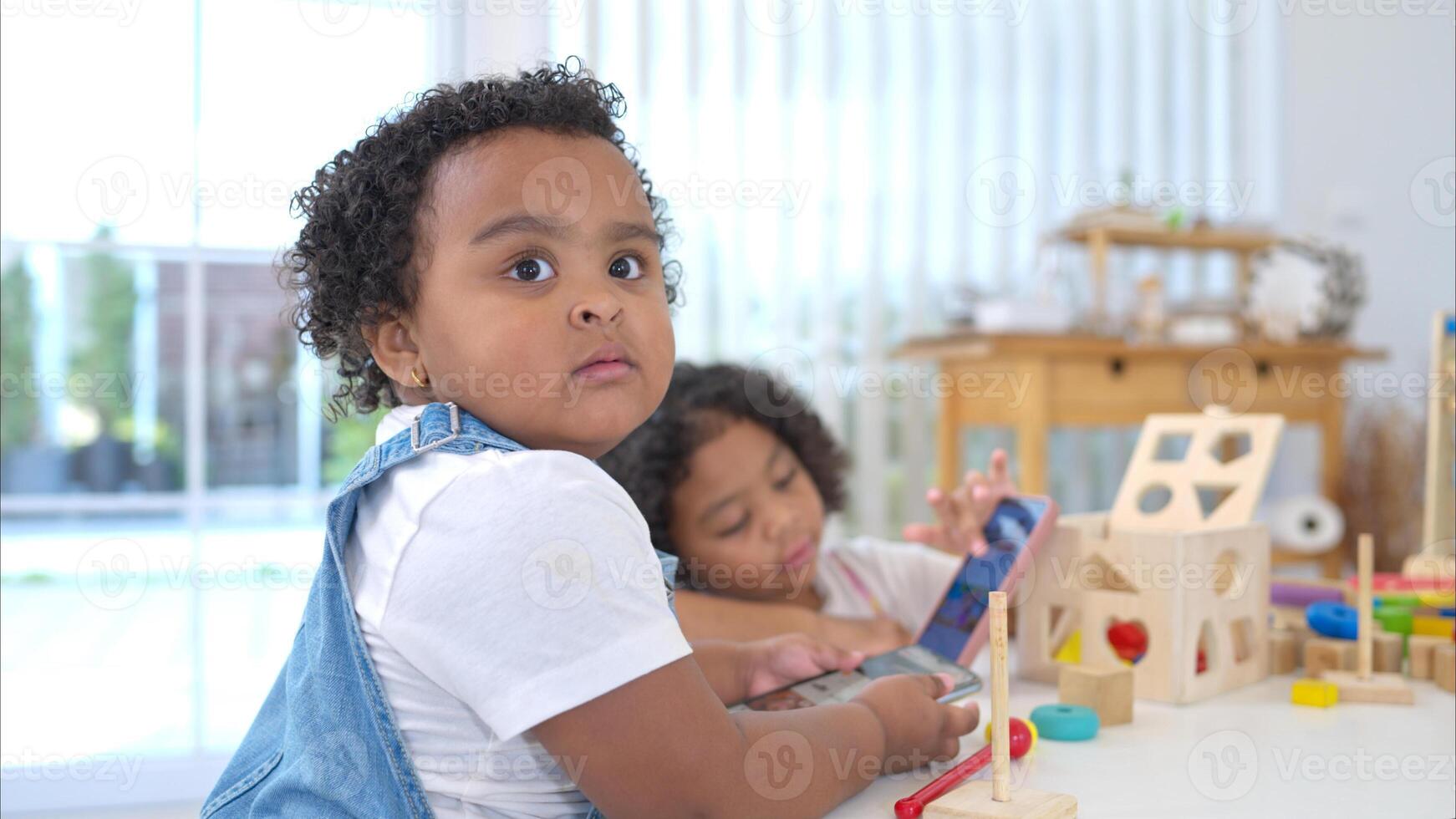 The older sister and younger sister sit on the floor and play the toy together photo