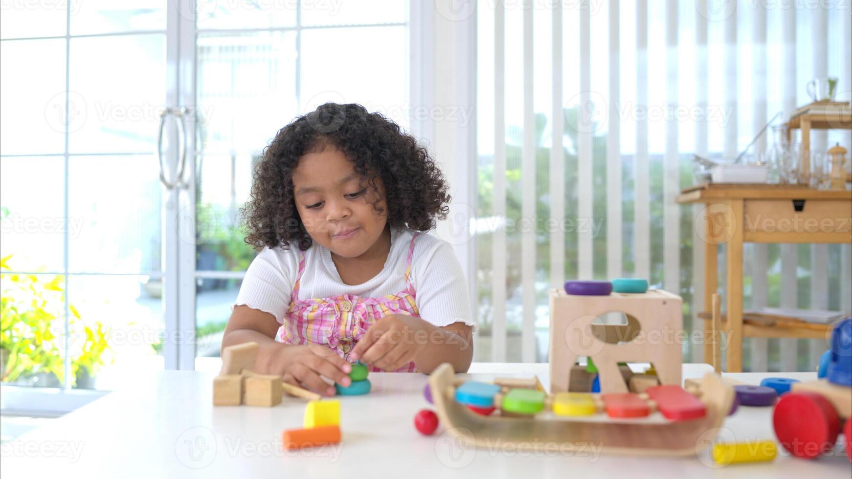 A little girl sit on the floor sit on the floor and play the toy photo