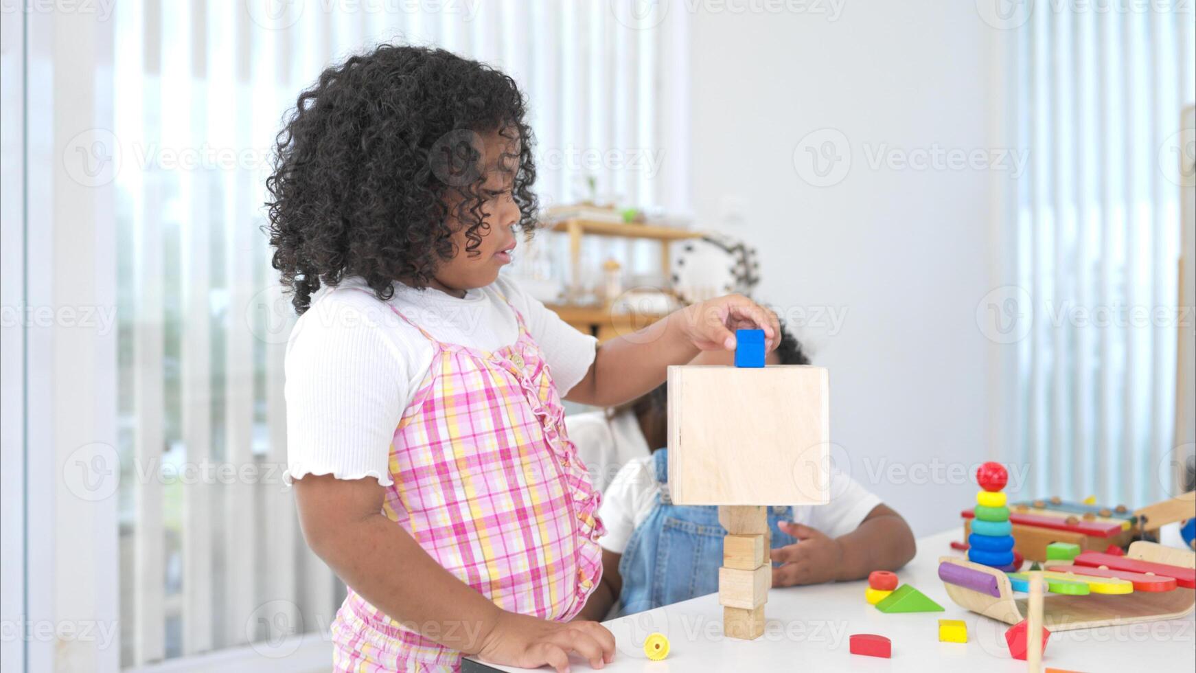 The older sister and younger sister sit on the floor and play the toy together photo