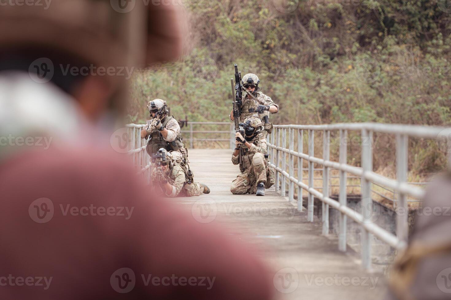 A group of Allied soldiers in camouflage wearing weapons clash with group of taliban soldiers photo