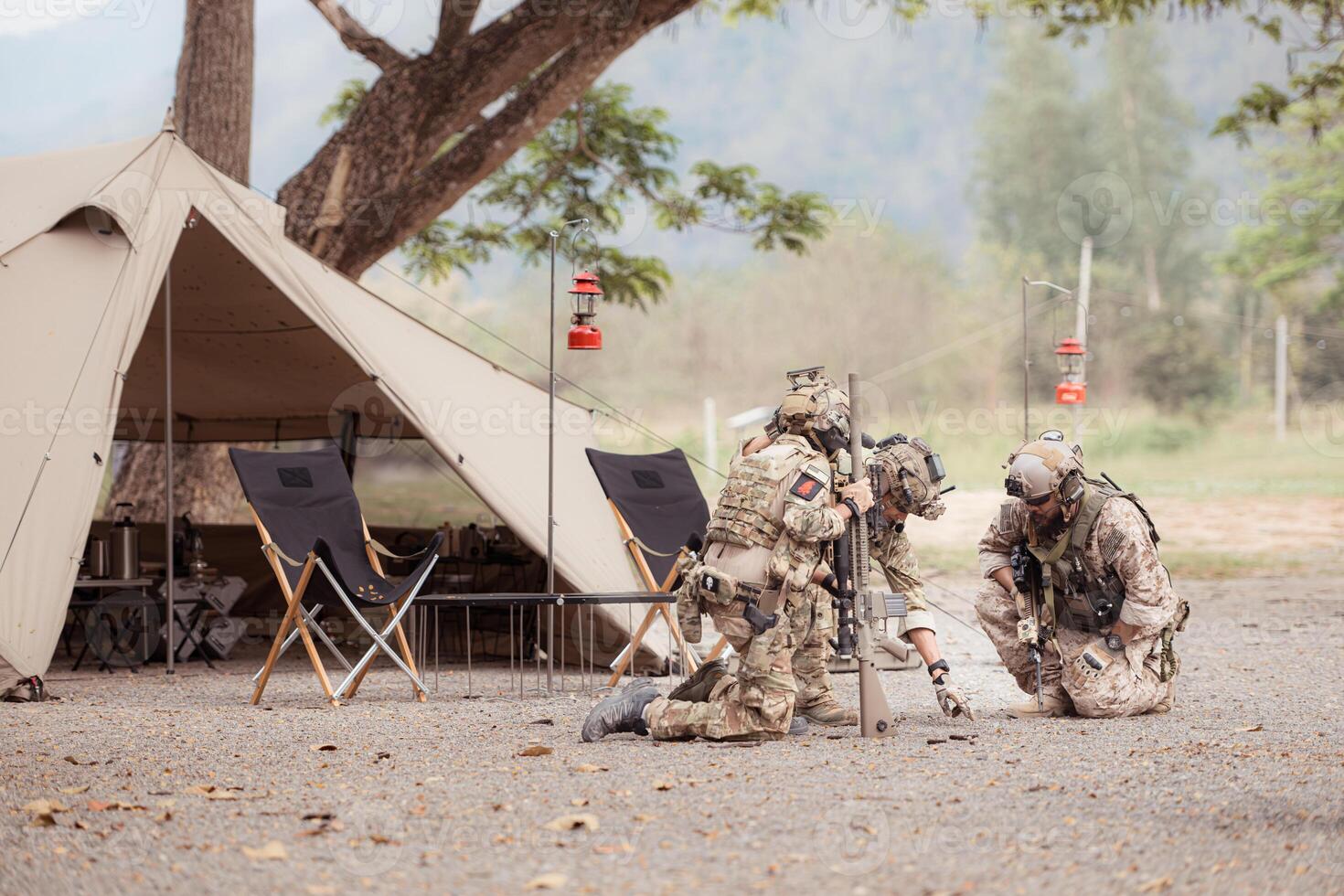 Group of soldiers in camouflage uniforms hold weapons in front of camp tent, Plan and prepare for combat training. photo