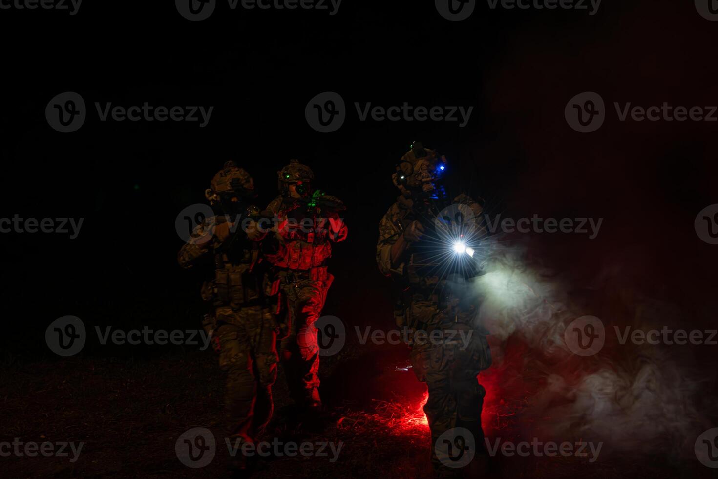 Group of soldiers in camouflage uniforms hold weapons with patrol missions at night photo