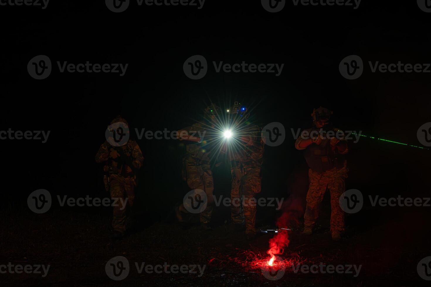 Group of soldiers in camouflage uniforms hold weapons with patrol missions at night photo