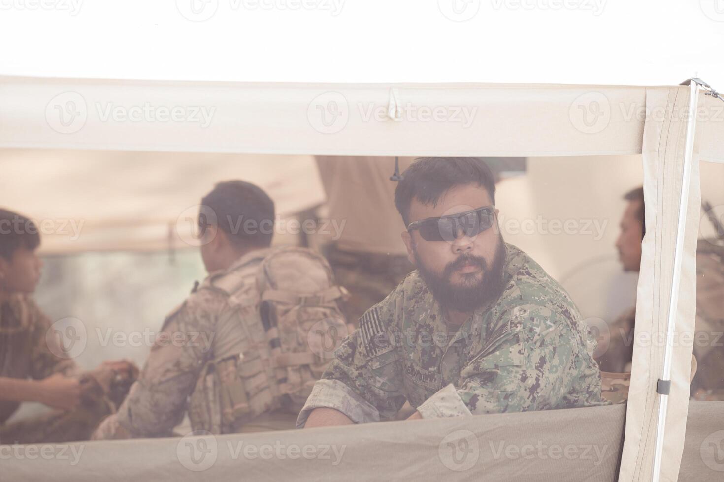 Group of soldiers in camouflage uniforms hold weapons in a field tent, Plan and prepare for combat training. photo