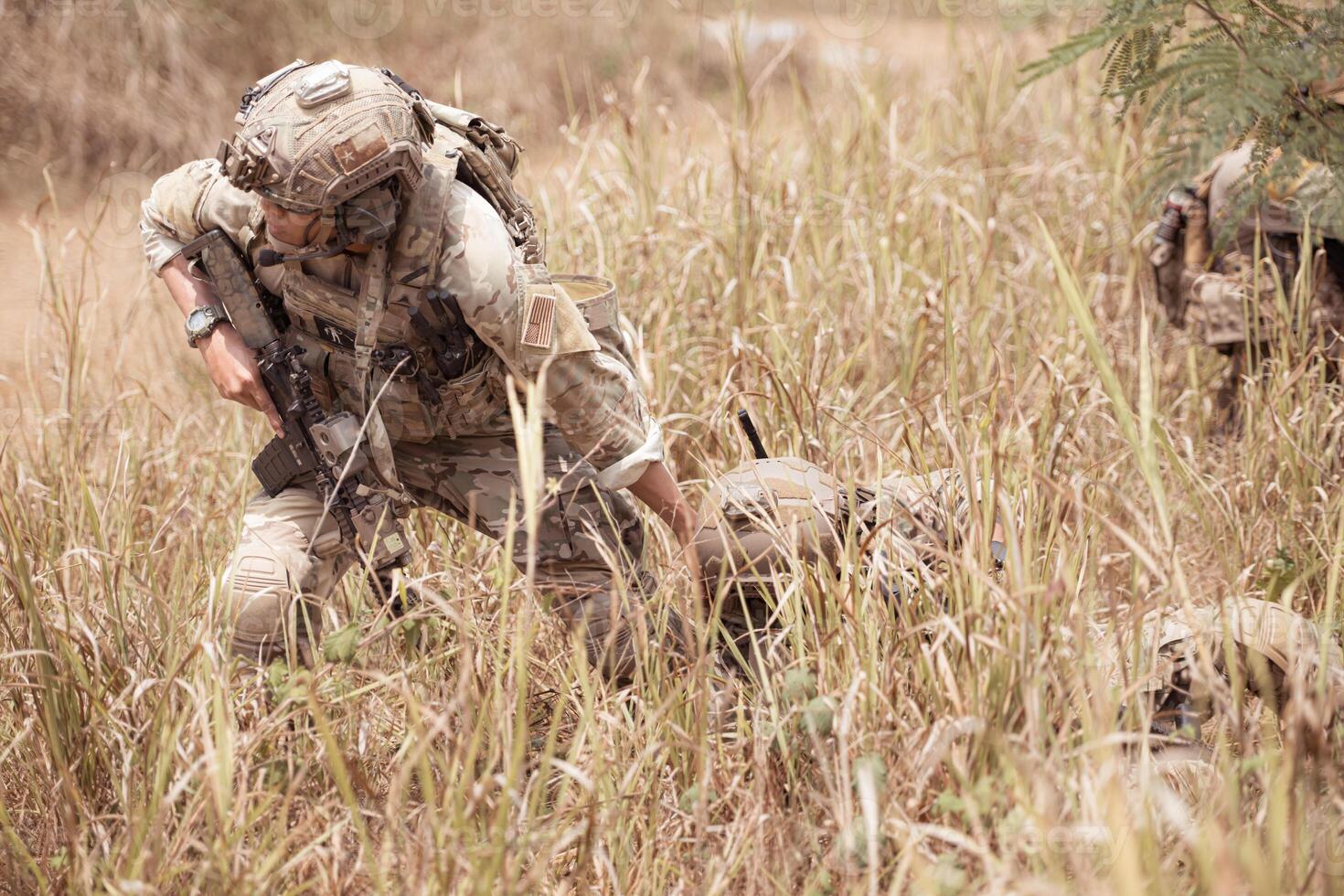 Soldiers in camouflage military uniforms carrying weapons, Reconnaissance missions in the tropical forest area with mission of helping those injured from being shot photo