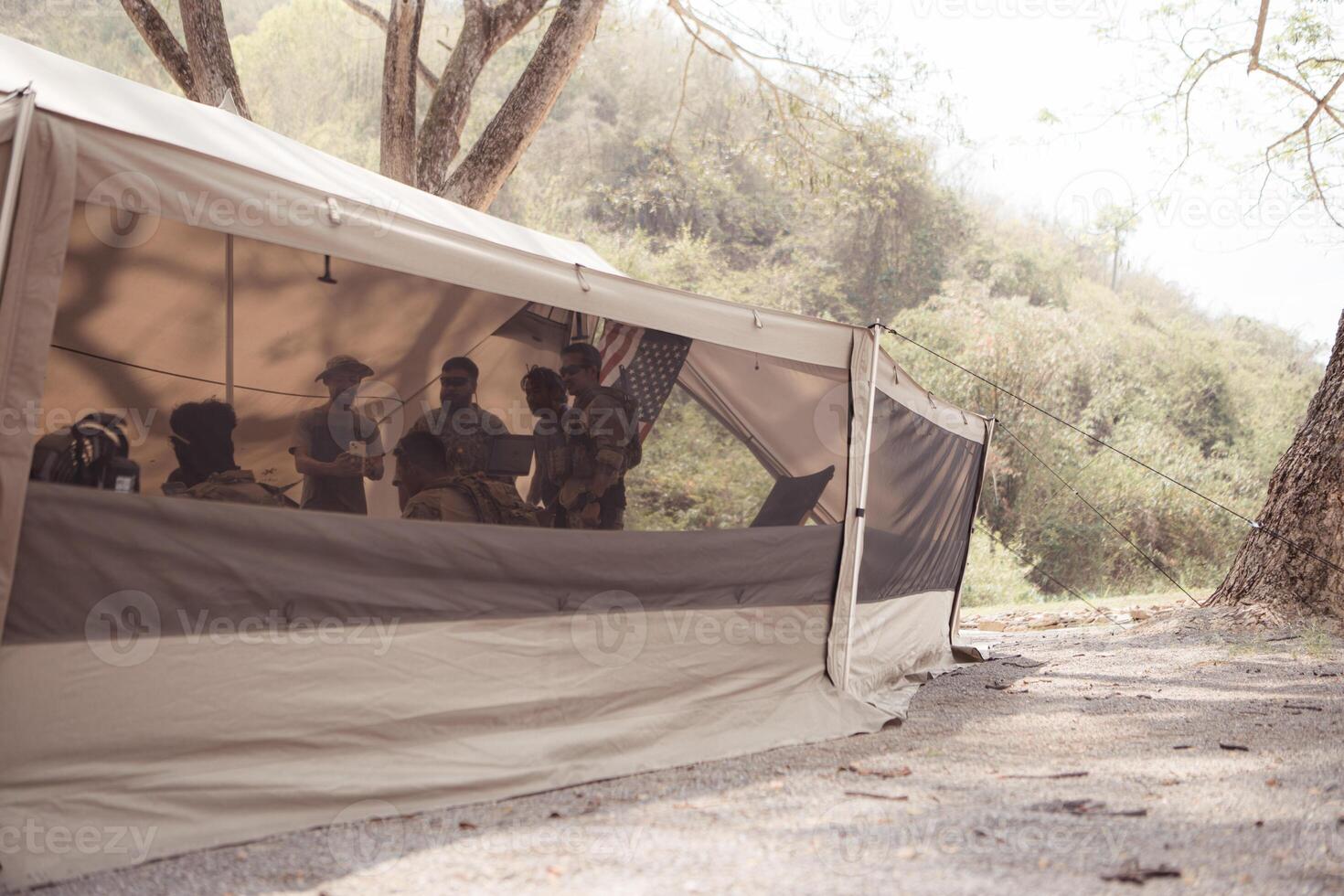 Group of soldiers in camouflage uniforms hold weapons in a field tent, Plan and prepare for combat training. photo