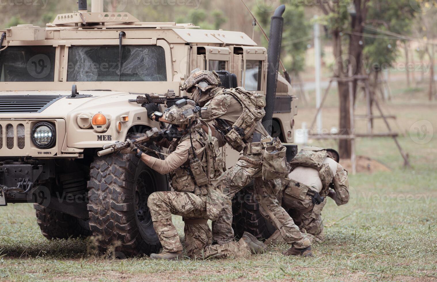 Group of soldiers in camouflage uniforms hold weapons in a jltv car, Plan and prepare for combat training. photo