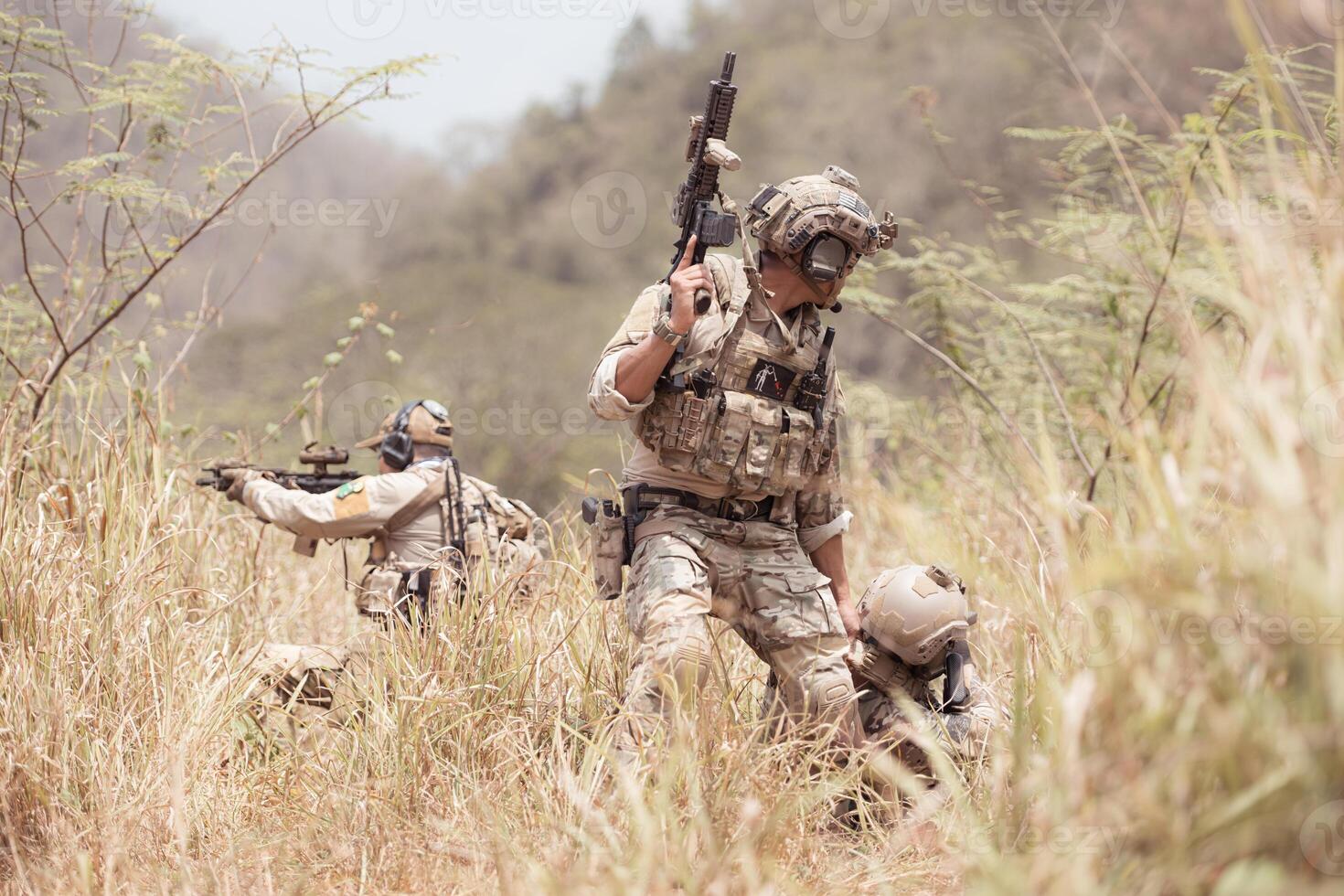 Soldiers in camouflage military uniforms carrying weapons, Reconnaissance missions in the tropical forest area with mission of helping those injured from being shot photo