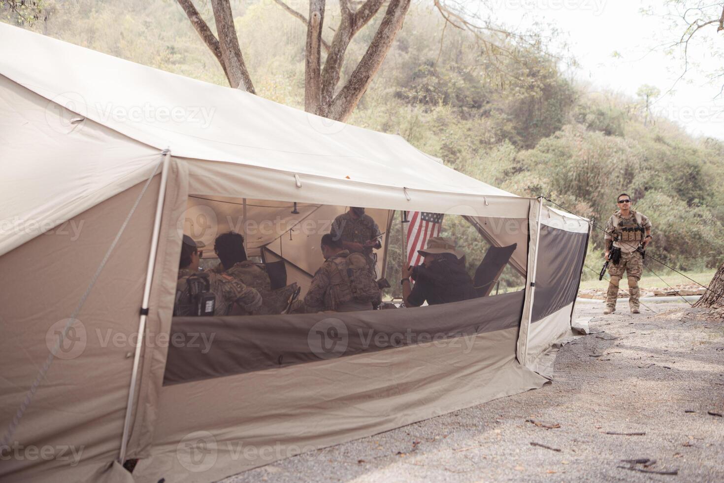 Group of soldiers in camouflage uniforms hold weapons in a field tent, Plan and prepare for combat training. photo