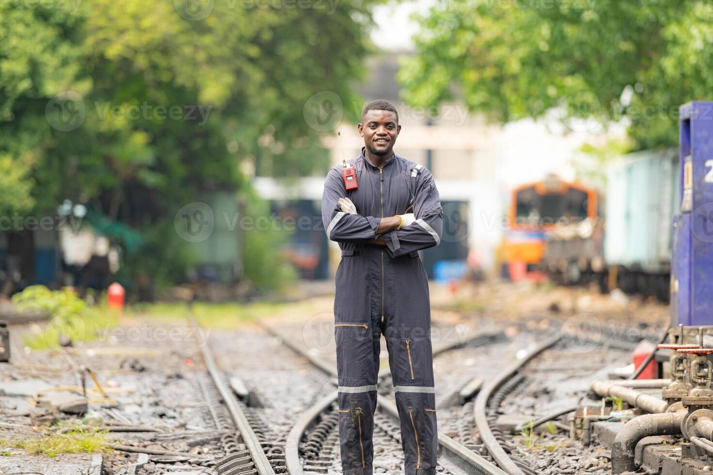 Portrait of a railway engineer standing on the tracks of a train in station platform. photo
