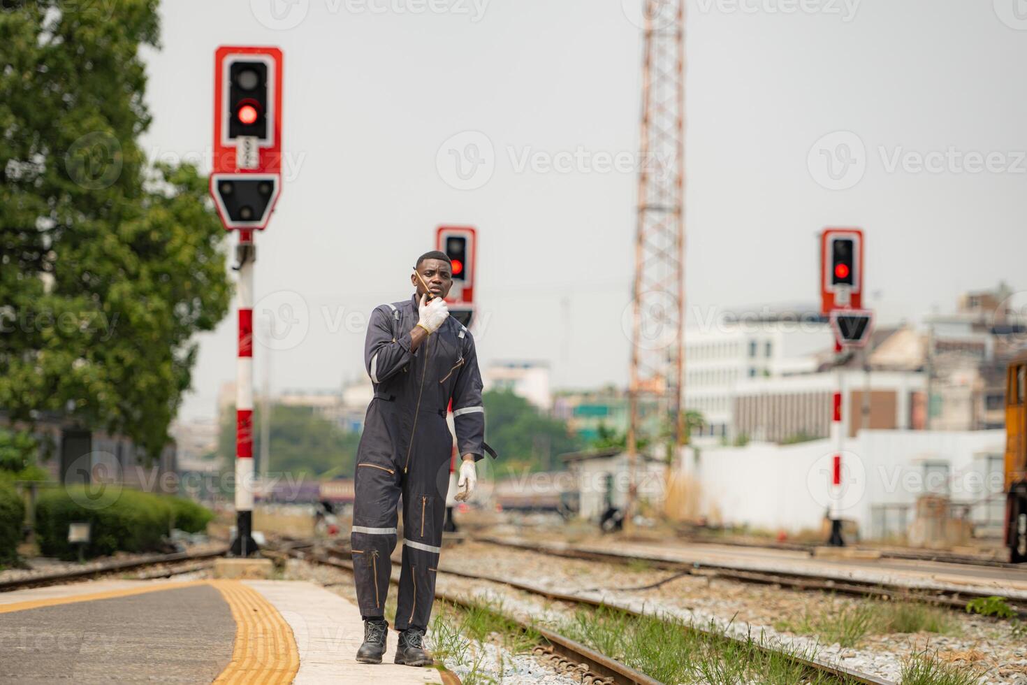 Portrait of a railway engineer, Check the tracks and use the walkie talkie to communicate with colleagues. While standing on the train station platform photo