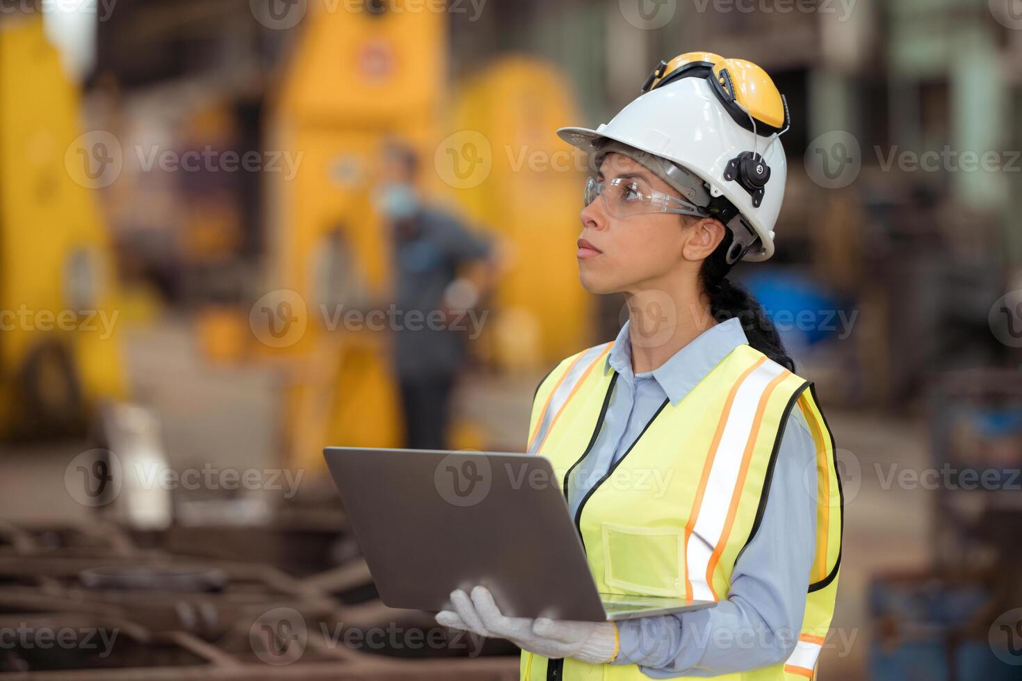 Portrait of railway technician worker in safety vest and helmet working with blueprint at train repair station photo