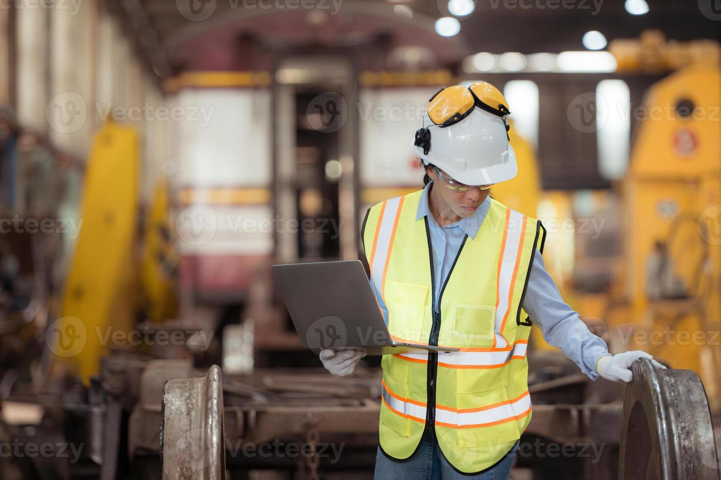 Railway technician in uniform and helmet inspect the train wheels removed from the locomotives in the train workshop. photo