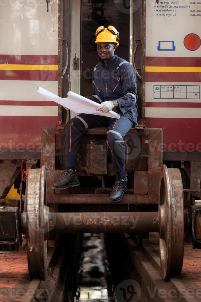 Railway technician in uniform and helmet inspect the train wheels removed from the locomotives in the train workshop. photo