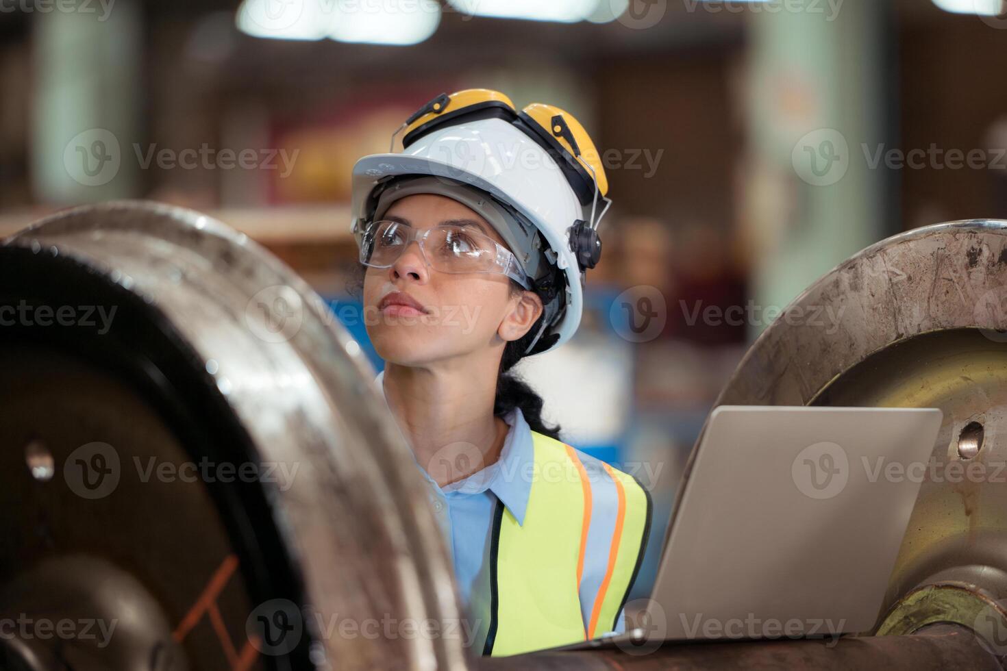Railway technician in uniform and helmet inspect the train wheels removed from the locomotives in the train workshop. photo