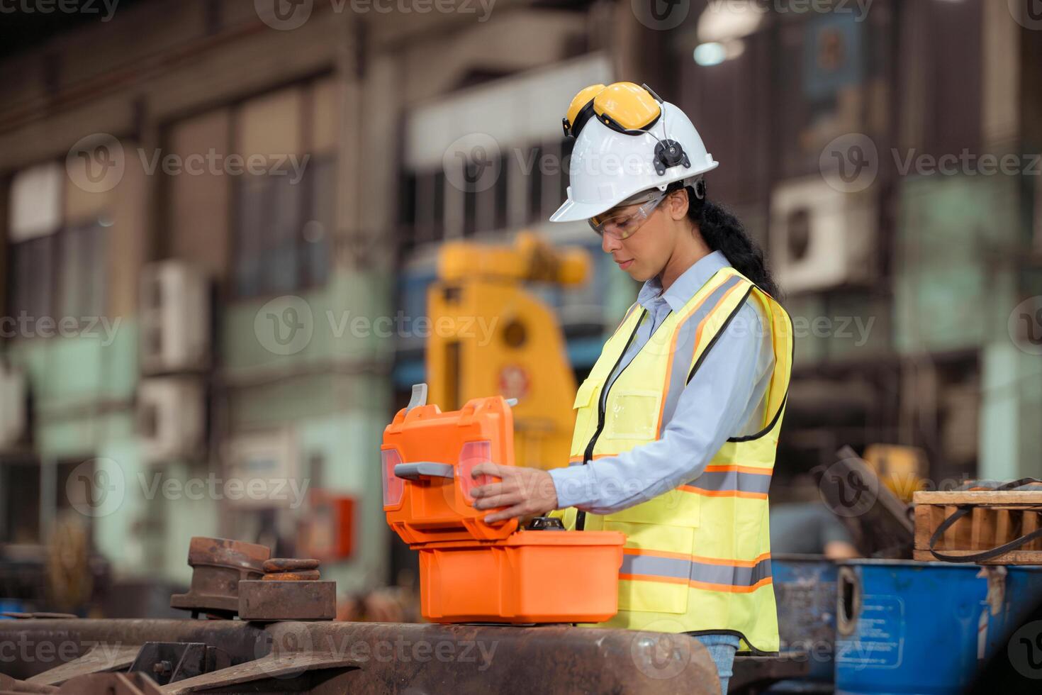 Portrait of railway technician worker in safety vest and helmet working with blueprint at train repair station photo