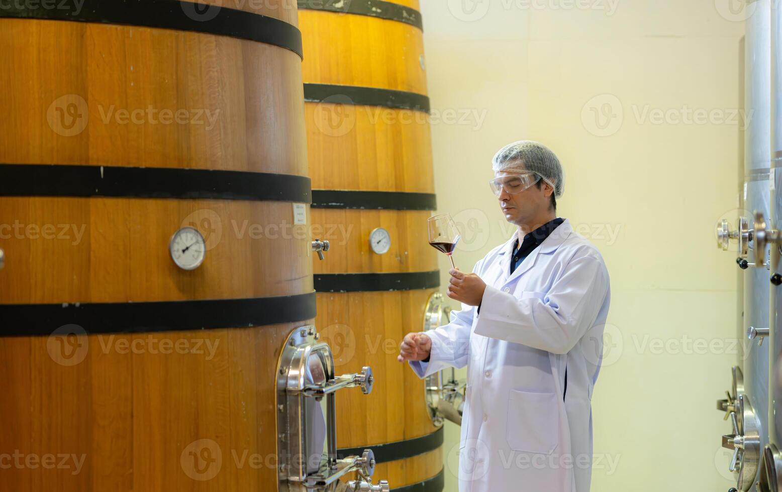 Mature male researchers and developers working in winery, Testing wine that has been fermented for a while. photo
