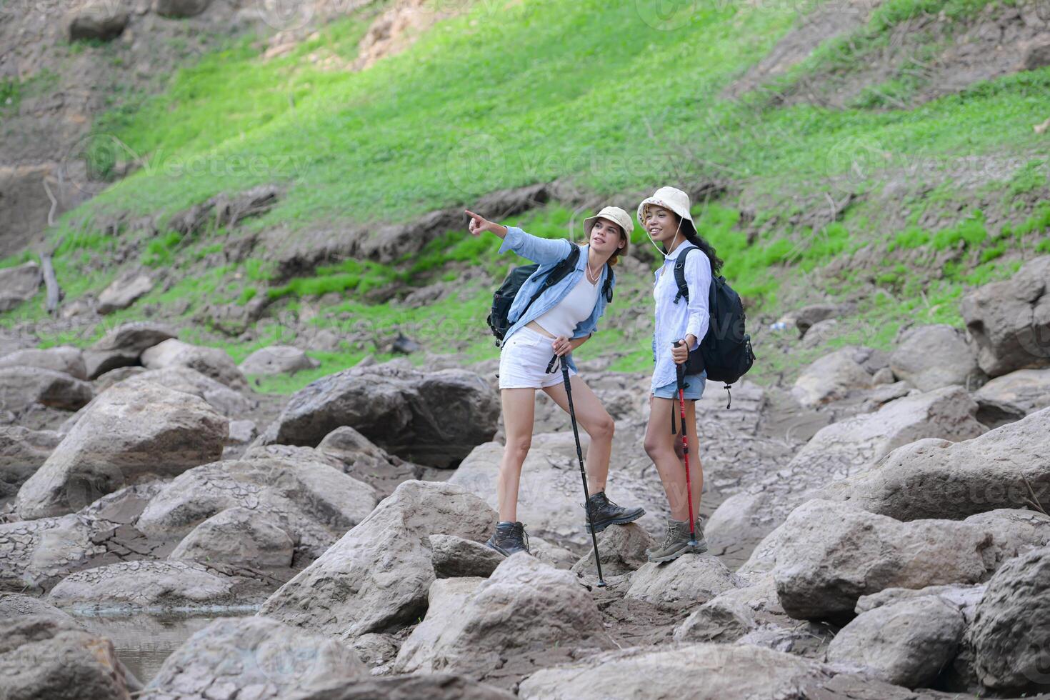 A group of friends going hiking in the streams of the tropical forest area. photo