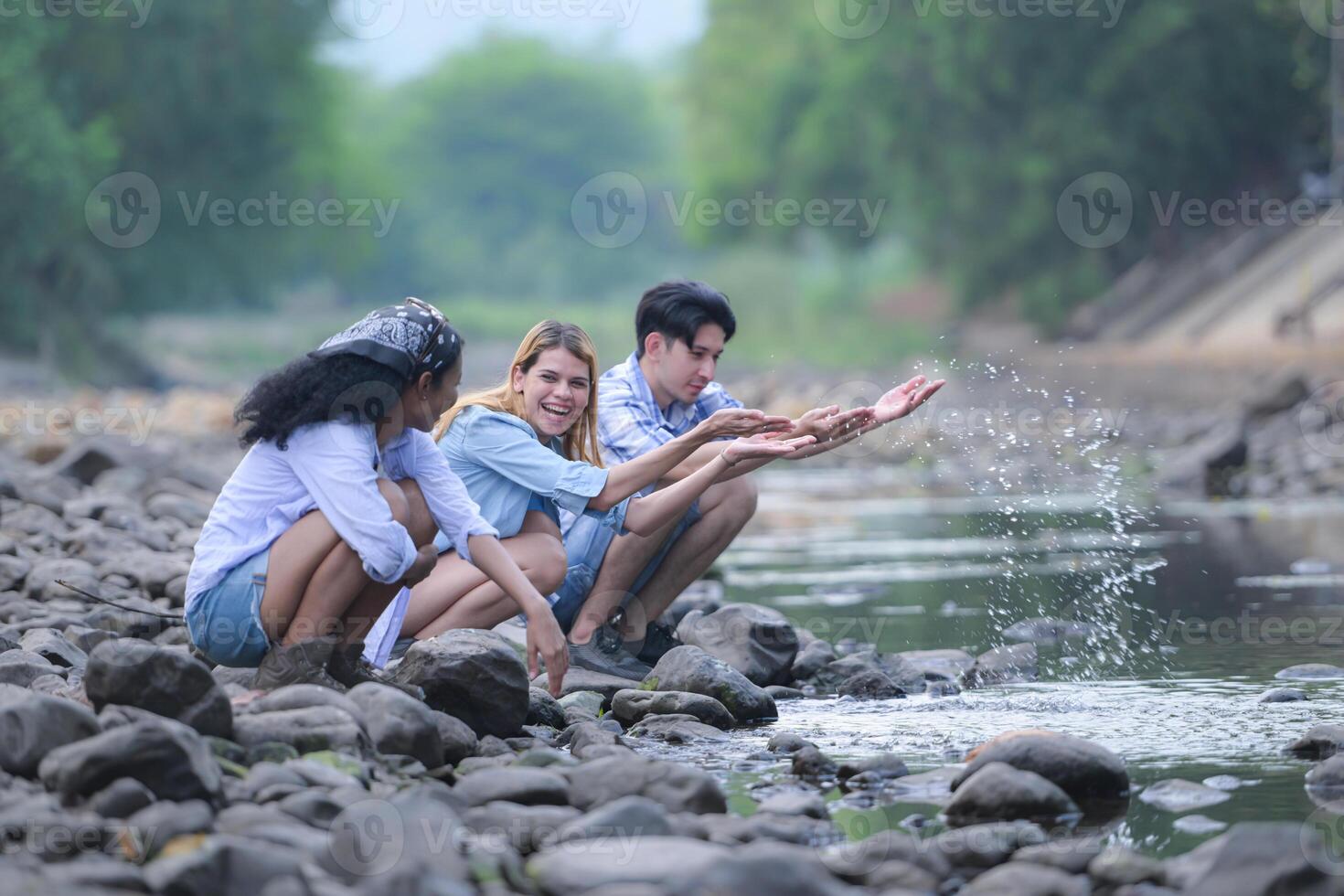 A group of friends are camping near a stream, but there is no water running. photo