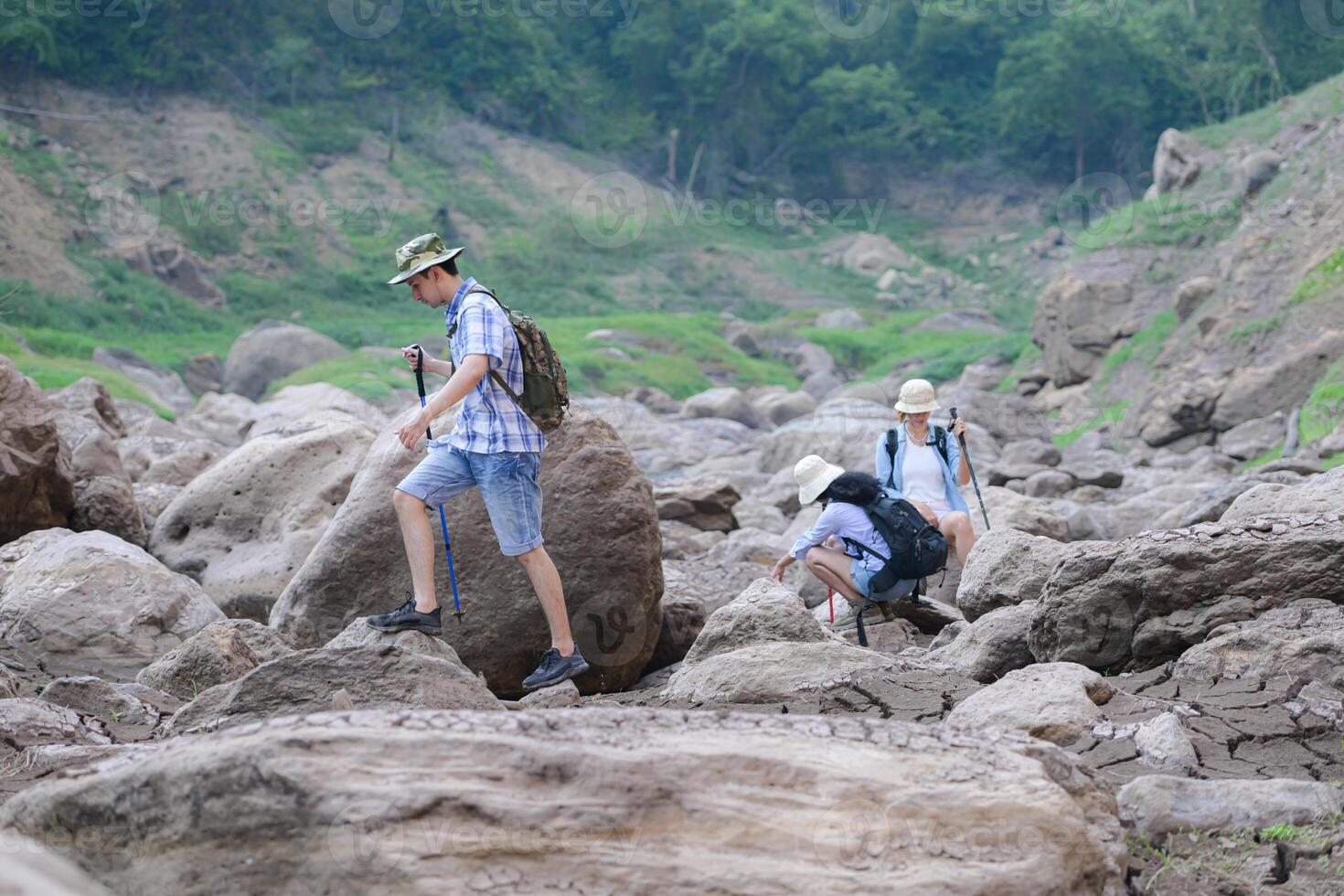 A group of friends going hiking in the streams of the tropical forest area. photo