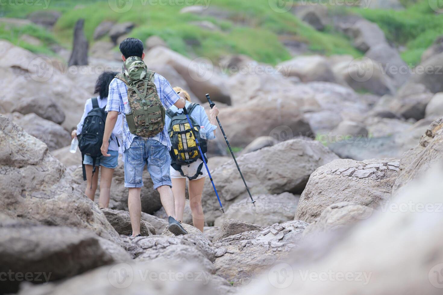 A group of friends going hiking in the streams of the tropical forest area. photo
