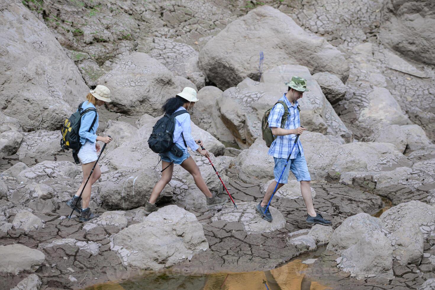 A group of friends going hiking in the streams of the tropical forest area. photo
