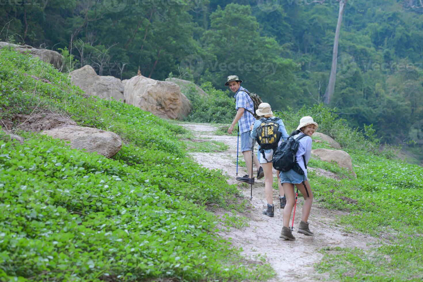 A group of friends going hiking in the streams of the tropical forest area. photo