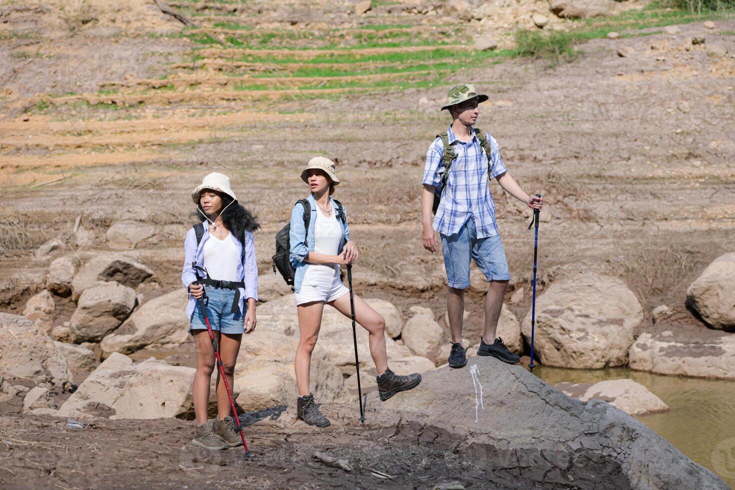 A group of friends going hiking in the streams of the tropical forest area. photo