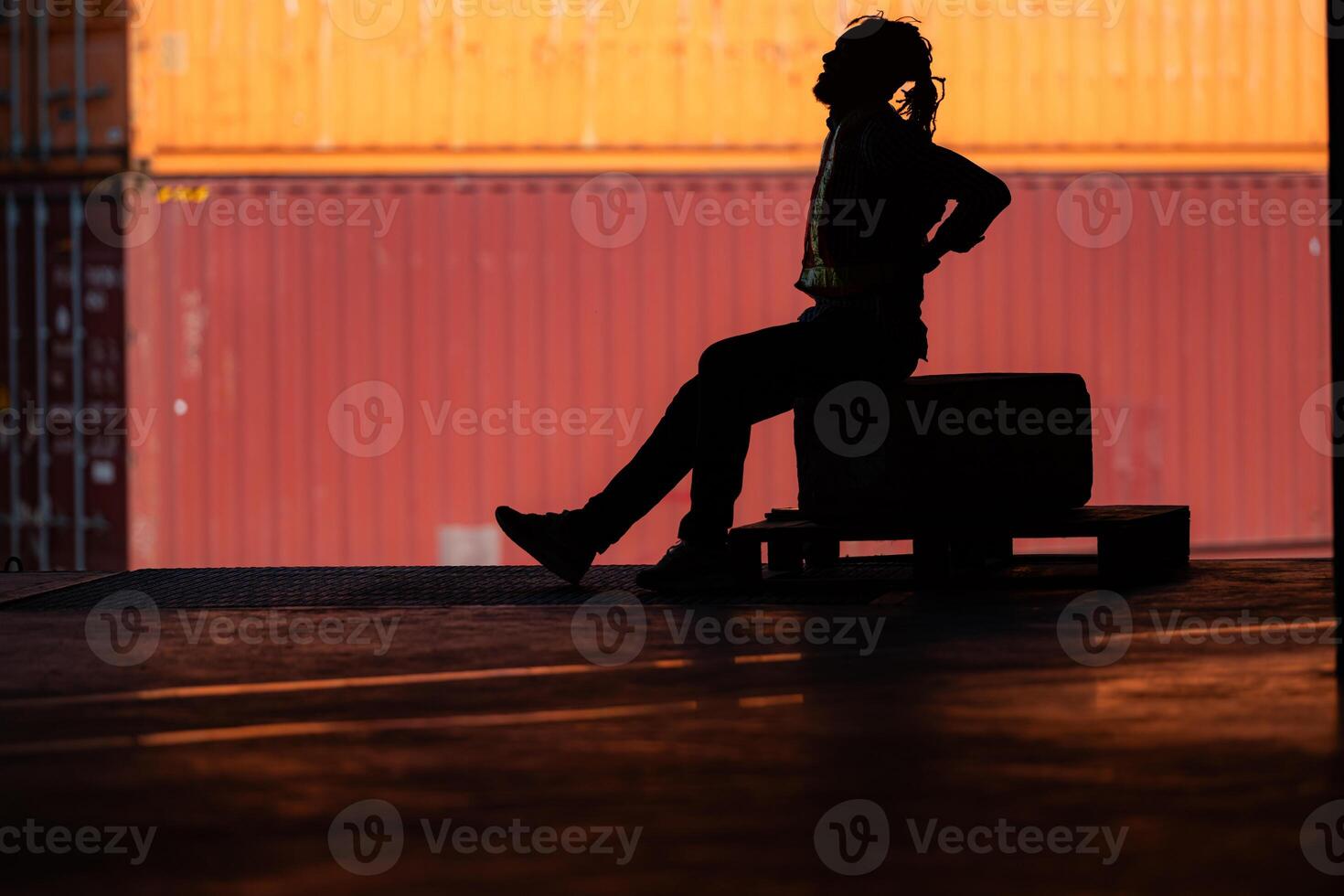 Warehouse worker's back pain from hard work while sitting and relaxing, Silhouette concept photo