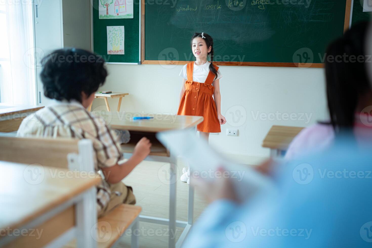 Children with classroom presentation activities in front of the classroom photo