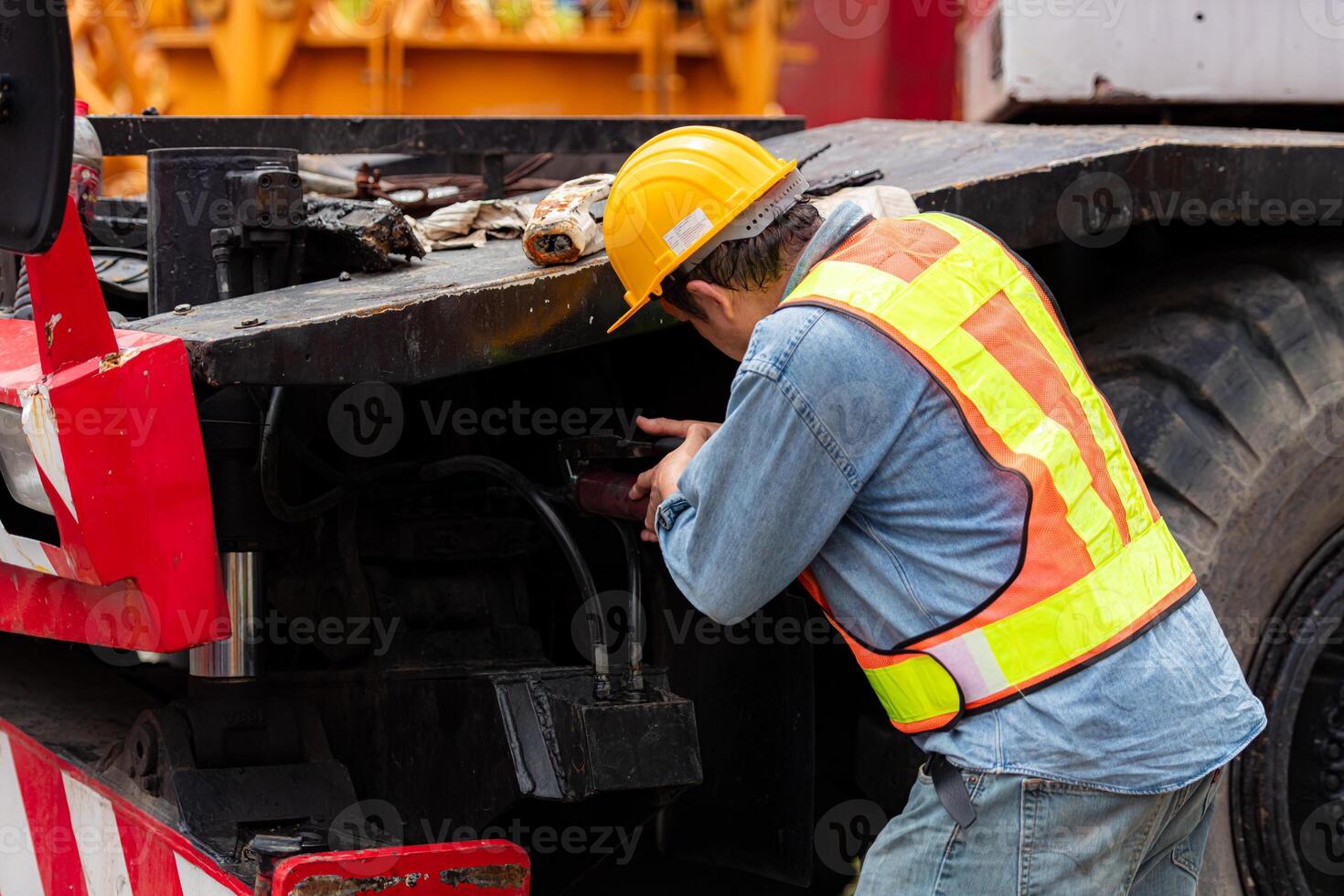 Engineers and technicians grease the wheel axle of a large crane before moving to the construction site photo