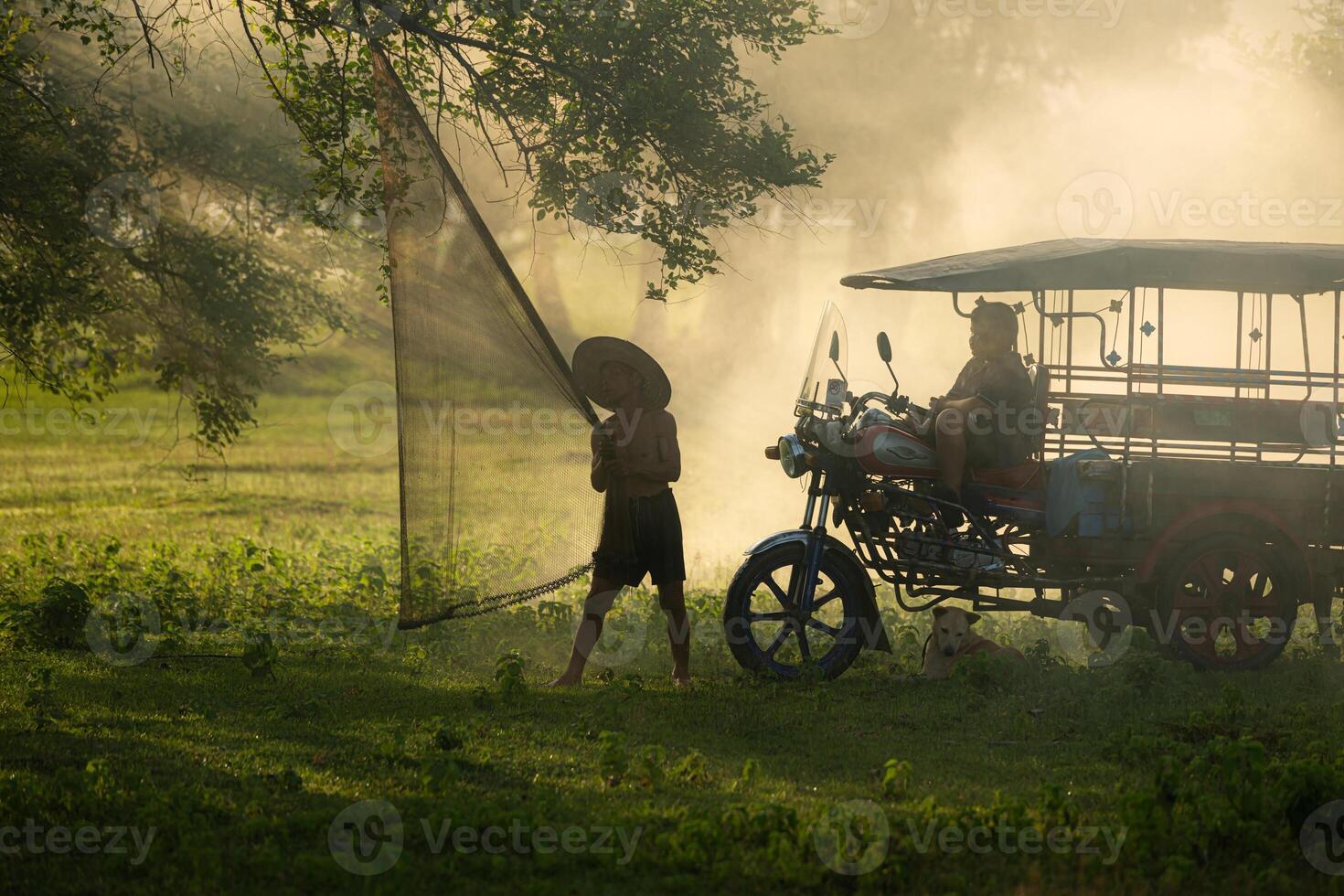 Local fisherman prepare a fishnet under the tree to capture fish in the lake photo
