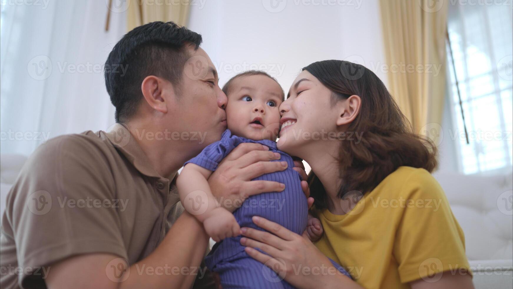 Parents and their little child play happily in the living room of the house photo