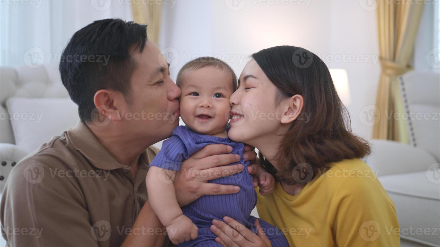 Parents and their little child play happily in the living room of the house photo
