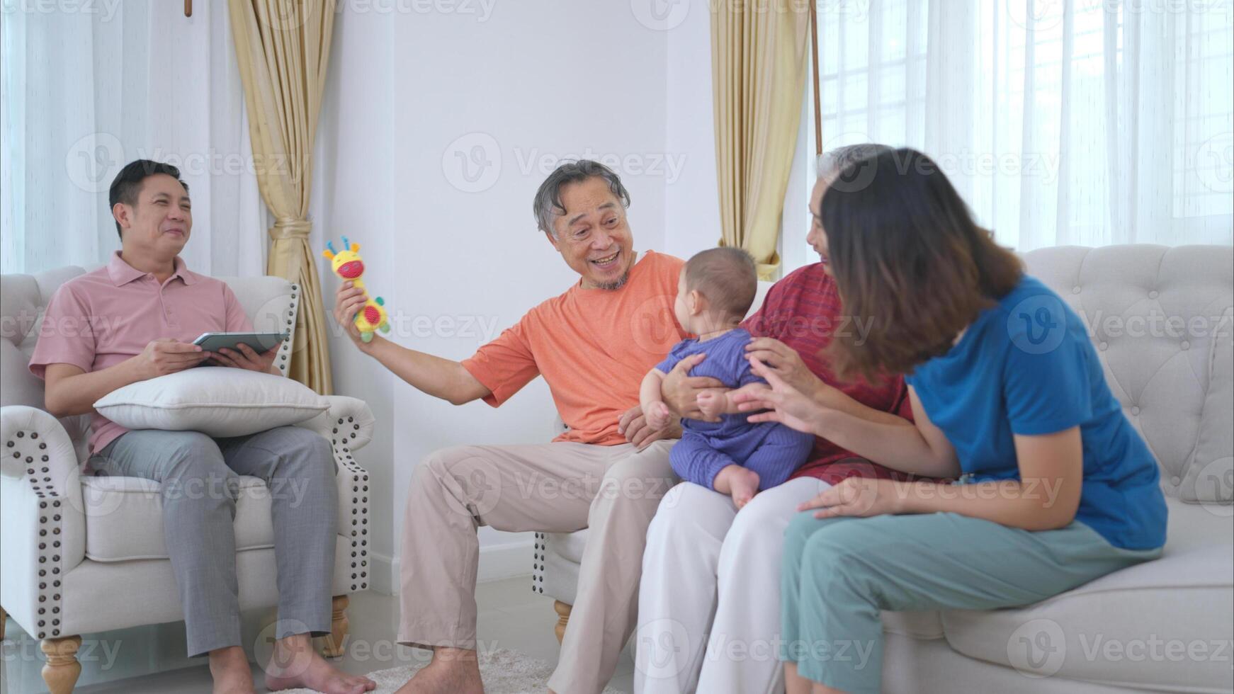 Grandparents and parents with their little child play happily in the living room of the house photo